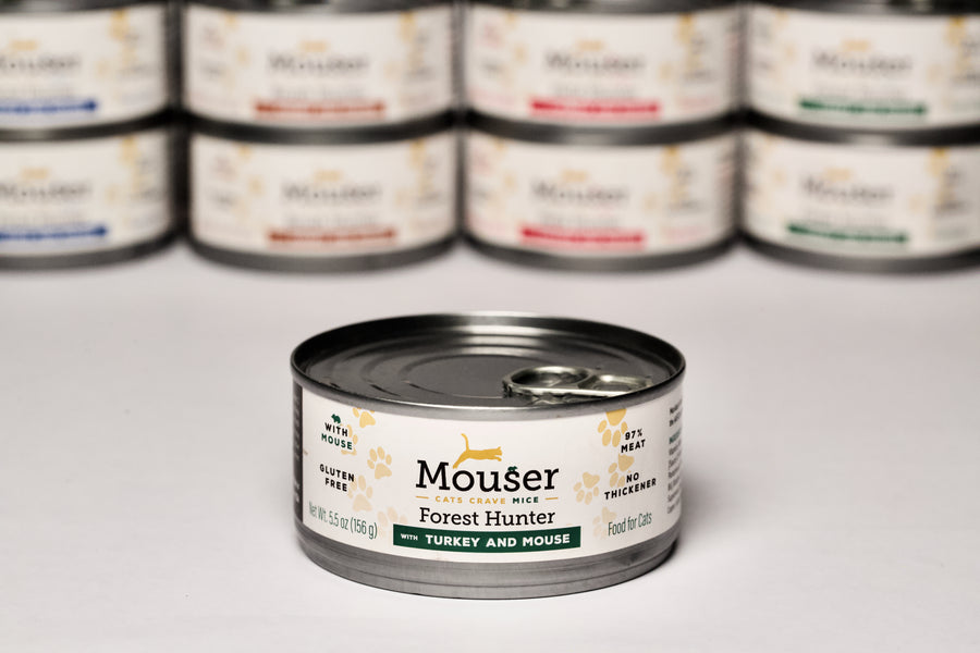 Mouser Forest Hunter Canned Cat Food. With Turkey & Mouse., Other Flavors Visible in Background. Gluten Free, BPA Free Can, No Thickener
