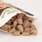 A few pieces of Badlands Ranch Freeze-Dried Superfood Bites Beef Liver Dog Treats out of the pouch