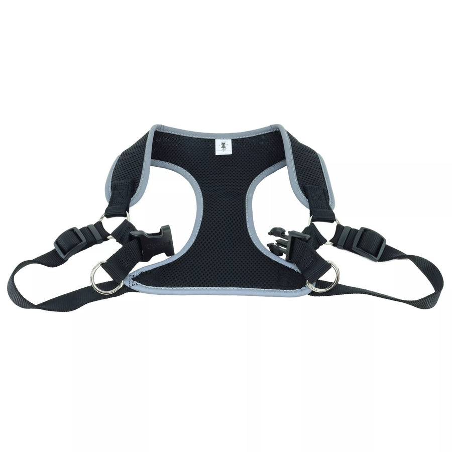 Close up of harness. Showing padded center piece. Adjustable straps on both sides. In the center shows a pinch buckle open and two D rings for leash attachment.