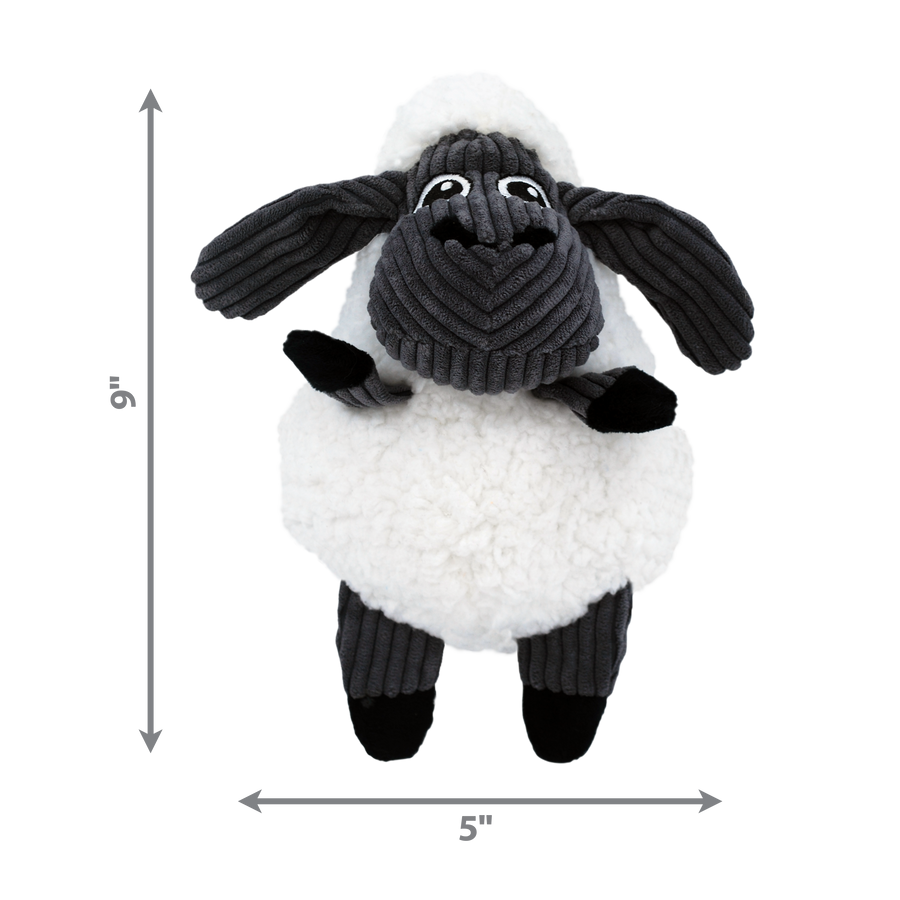A KONG Sherps Floofs sheep plush dog toy, measuring approximately 9 inches in height and 5 inches in width. The toy has a round, soft white fleece-like body with a black corduroy-textured face and floppy ears. It features embroidered eyes, a black plush nose, and short black plush limbs. Measurement arrows along the sides indicate the toy’s dimensions.