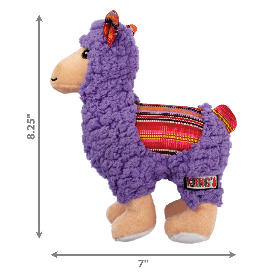 A KONG Sherps llama plush dog toy, measuring approximately 8.25 inches in height and 7 inches in width. The toy has a soft, purple fleece-like body with a beige muzzle and embroidered eyes. Its ears feature a colorful woven fabric with red, orange, and yellow stripes, which matches the saddle-like fabric on its back. The llama stands on beige plush legs with white hooves, and it has a small, fluffy tail. Measurement arrows along the sides indicate the toy’s dimensions.