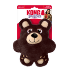 A KONG Snuzzles Bear plush dog toy in its original packaging. The toy is a soft, round, brown bear with a fuzzy texture. It features embroidered eyes, a beige muzzle with a black plush nose, and a stitched smiling mouth. The bear has rounded ears with beige inner linings and small embroidered paw prints on its feet. The packaging is red and white, displaying the KONG logo, the word 'Snuzzles'. The packaging also highlights that the to that the toy squeaks.