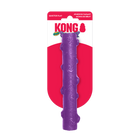 A KONG Squeezz Crackle Stick dog toy in its original packaging. The toy is a long, cylindrical stick-shaped chew toy in vibrant purple with a slightly textured surface featuring raised bumps. It is designed for interactive play and features a crackling sound for added engagement. The packaging has a red and white KONG-branded card with the words 'Quieter Play' in the upper left corner, indicating its noise-reducing design.