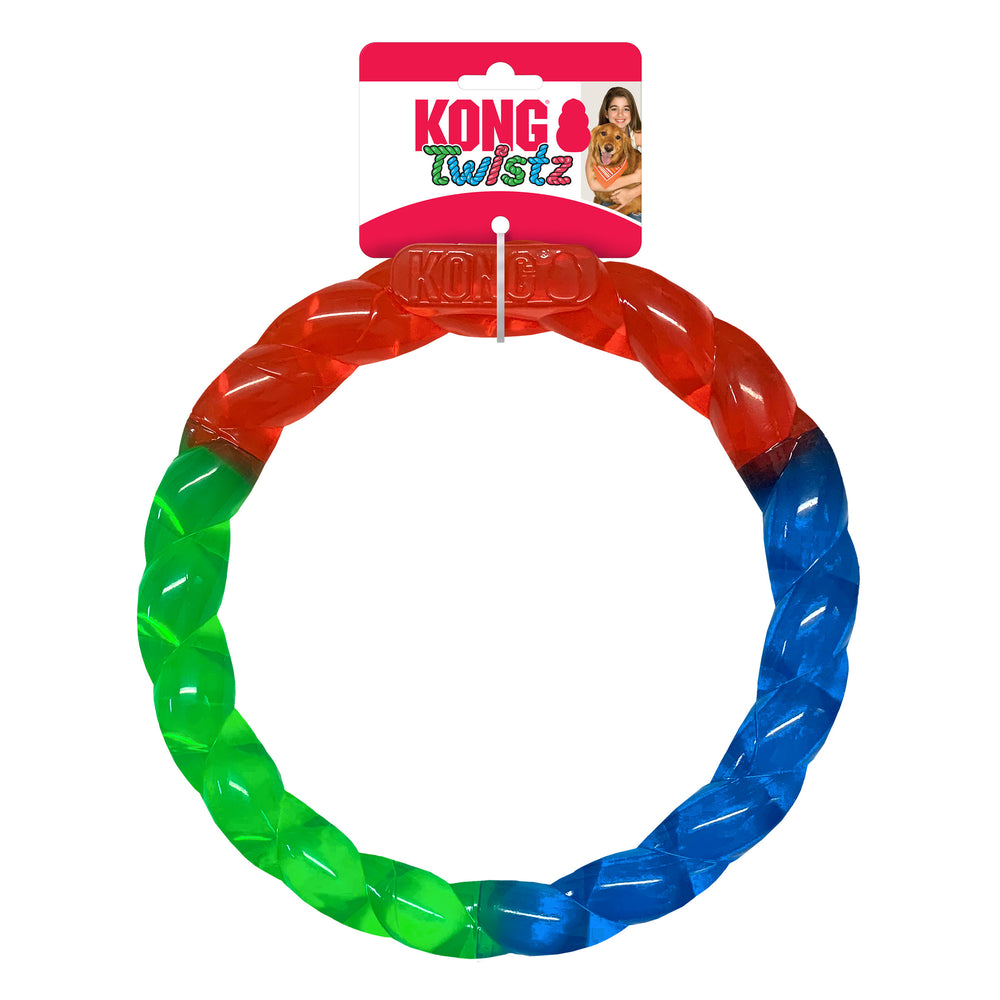 The KONG Twistz Ring Dog Toy in its original packaging. The toy is a circular, braided ring with vibrant translucent colors—red, blue, and green. The packaging features the KONG logo, the product name 'Twistz,' and an image of a smiling woman with her golden retriever. The ring is designed for interactive play and chewing.
