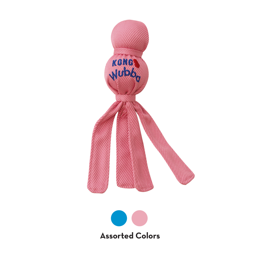 KONG Wubba Puppy Dog Toy in light pink, featuring a durable fabric-covered ball with a smaller ball on top, and long floppy tails for interactive tugging and shaking. The 'KONG Wubba' logo is printed on the fabric, making it an engaging toy designed for puppies. Two small circles indicating product comes in light blue and light pink.
