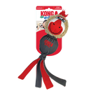 A KONG Wubba Zoo Mandrill Dog Toy in its original packaging. The toy has a round, plush head resembling a mandrill, with a tan furry face, large embroidered eyes, a red and white snout, and a tuft of red fur on top. The body is made of durable dark gray fabric, with the 'KONG Wubba' logo printed in red. Multiple long fabric tails in red and gray extend from the bottom, designed for interactive play such as tugging and shaking.