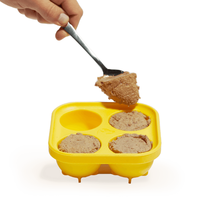 Hand filling Woof Pupsicle Silicone Treat Tray with food