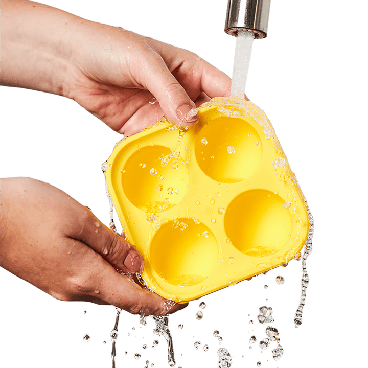 Hand washing Woof Pupsicle Silicone Treat Tray under running water