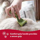 Person using brush on cat's back. Comfort-grip handle provides a secure grip. Safari de shedding tool for cats.