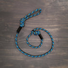 Wilderdog Reflective Slip Leash in Pacific Blue colorway laid flat on a wooden surface, showing the rope construction, adjustable slip loop, and knotted handle