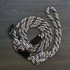 Wilderdog Small Carabiner Dog Leash in Black and White coiled on dark wood surface, thick black and white braided rope with black Wilderdog carabiner clip and black branded grip.