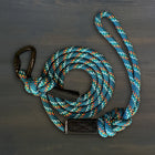 Wilderdog Small Reflective Carabiner Dog Leash in Pacific Blue coiled on dark wood surface, teal braided rope with multicolor speckle pattern, black Wilderdog carabiner clip, and black branded grip.