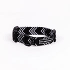 Wilderdog Orca ultralight dog collar on white background, showing black webbing with white chevron arrow pattern, black quick-release buckle, D-ring, and Wilderdog logo patch.