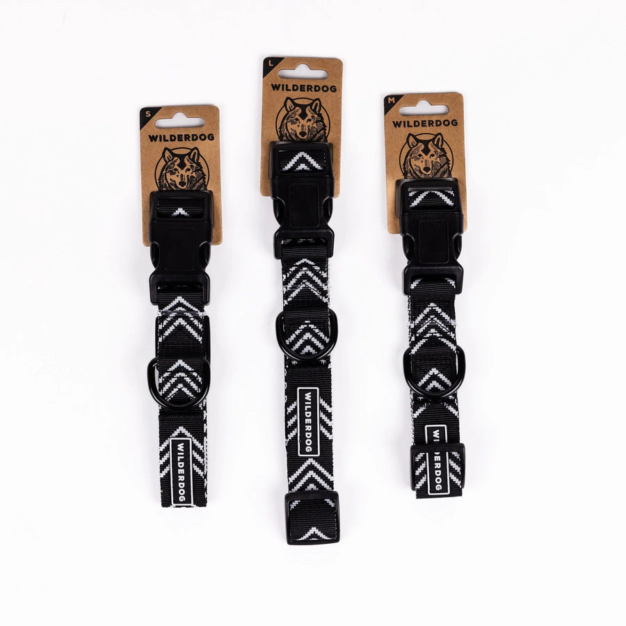 Three Wilderdog Orca ultralight dog collars in Small, Large, and Medium sizes displayed on branded kraft paper hang tags against a white background, showing black chevron pattern webbing.