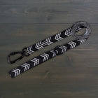 Wilderdog Ultralight Dog Leash in black and white chevron pattern laid flat on dark wood surface, showing black Wilderdog carabiner clip, D-ring, and branded label.