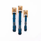 Three Wilderdog Pacific Blue waterproof dog collars in Medium, Large, and Small sizes standing upright on branded kraft paper hang tags with wolf illustration against a white background, showing teal blue coated webbing with topo map pattern and black hardware.