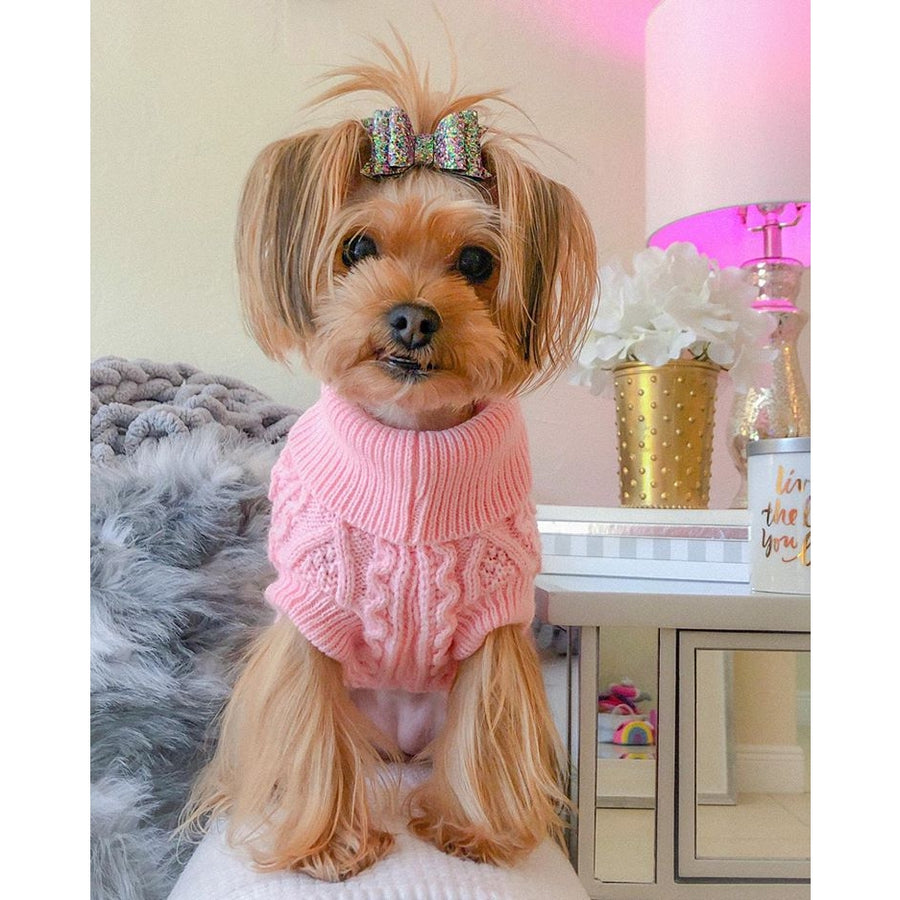 Parisian Pet Pullover Cable Knit Dog Sweater in Pink, dog with a ribbon clip wearing pink sweater